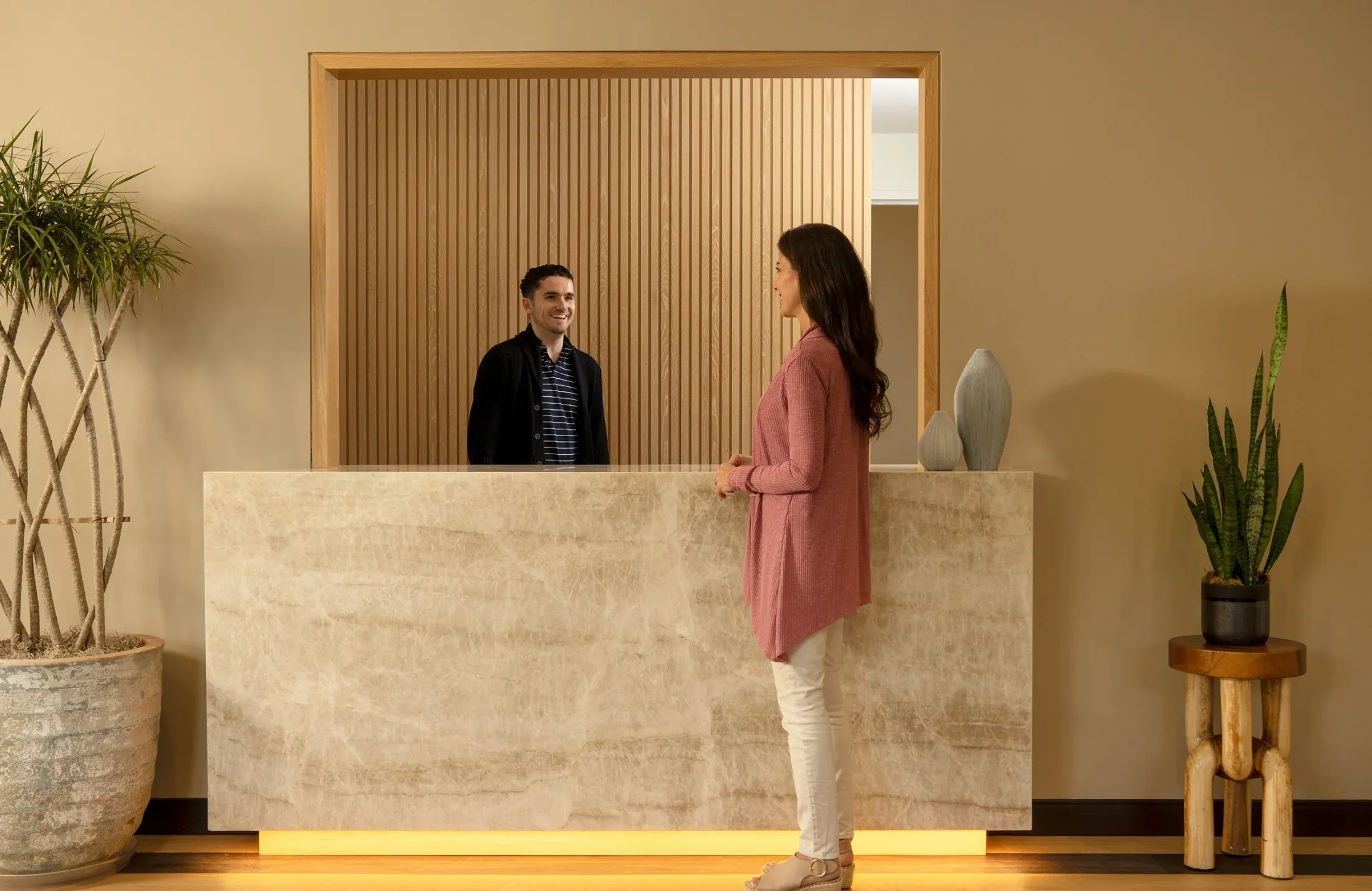 The reception desk at Griffin Concierge Medical in Tampa, a PPA member practice: oak slatting, a stone counter, a patient checking in.