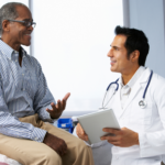 Doctor and patient engaged in warm, friendly conversation during consultation.