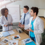 Medical team in white coats around conference table discussing growth strategies for how to grow a medical practice.